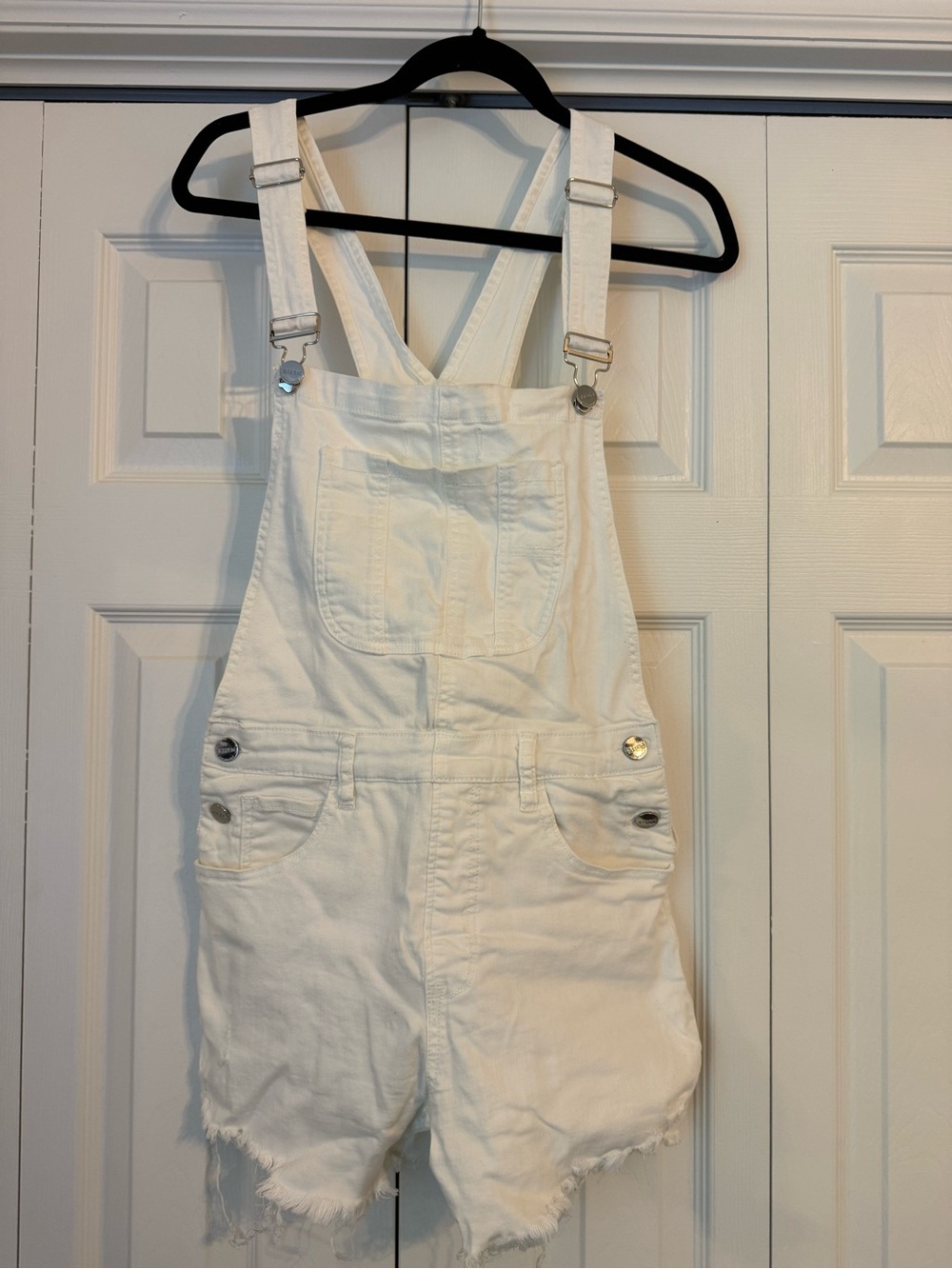 Risen Women’s White Short Denim Overalls with Adjustable Straps and Frayed Hem.